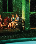 Outdoor scene with Motion Laser Holiday Projector With Thousands Of Lights, illuminating friends on patio with moving light modes.