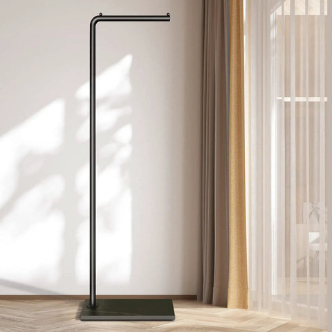 Matte Black Metal Coat Rack Dope Modern Clothing Tree With Heavy Slate Base in a sunlit room corner