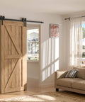 Wooden sliding barn door installed on a track in a sunlit living room next to a sofa and window with curtains.