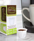 Disposable Paper Filters For Reusable K Cup Pods That Give You A Smoother Cleaner Brew No Mess Fits All Brands And Refillable Liners 200 Count Easy To Use next to a coffee machine and mug
