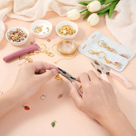Hands using pliers with DIY Lip Gloss Keychain Craft Kit With Enamel Charms And Chains Pliers Hole Punch Jump Rings Gift Bags