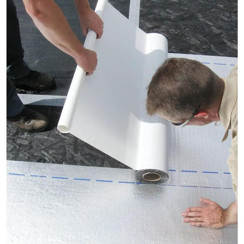 Peel and Seal Self Stick Roll Roofing Aluminum 36 Inch Wide Durable Self Adhesive Roofing Material For Quick Patches And Long Lasting Leak Protection Exterior Grade being applied by two workers on a roof.