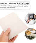 Hand holding a beige mica plate sheet for microwave, showcasing heat insulation properties; ideal for household oven and repair kit.