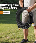 Haeteir 50ft garden hose, black with brass fittings, coiled and held outdoors