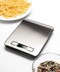 Digital Kitchen Scale With 11 Lb Capacity, Grams And Ounces, Stainless Steel Platform, Backlit Display, Tare Function next to pasta dish