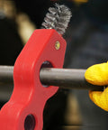 Close-up of red 4-in-1 copper pipe cleaner with wire brush tips for deburring and cleaning 1/2 in and 3/4 in pipes.