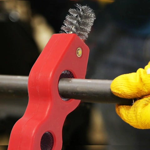 Close-up of red 4-in-1 copper pipe cleaner with wire brush tips for deburring and cleaning 1/2 in and 3/4 in pipes.