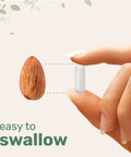 Hand holding a vegetarian capsule next to an almond, showcasing size comparison for Lithium Orotate 5mg for Everyday Balance, 240 Vegetarian Capsules