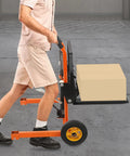 Person pushing Hydraulic Pallet Jack With Adjustable Forks For Quick Lifts loaded with boxes, tangerine finish, in warehouse