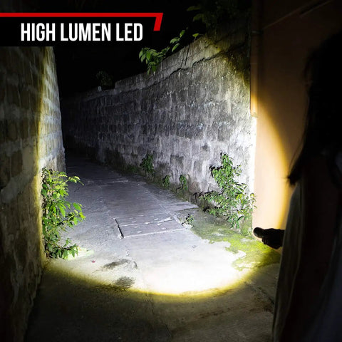 Person using Ultra Bright LED Flashlight Kit S1050 in an alley, showcasing its high-lumen output with zoom feature at night.