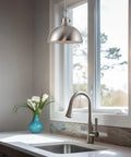 Petite Retro Metal Dome Pendant Light In Brushed Nickel Finish over kitchen sink with faucet in bright window setting.