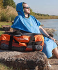 Man sitting on rock with 100L Mesh Dive Duffel Bag For Scuba Snorkeling Freediving And Swimming Gear With Quick Drain Mesh
