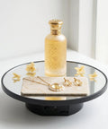 JAYEGT Motorized Rotating Display Stand, 10-Inch Mirror Finish Turntable With 11 Lb Load Capacity showcasing a perfume bottle and jewelry.
