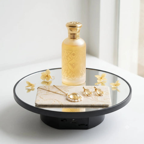 JAYEGT Motorized Rotating Display Stand, 10-Inch Mirror Finish Turntable With 11 Lb Load Capacity showcasing a perfume bottle and jewelry.