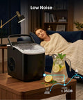 Countertop Ice Maker With Handle Delivers 9 Bullet Ice Cubes In 6 Minutes, Up To 26 Lbs Per Day on a table next to a sleeping person