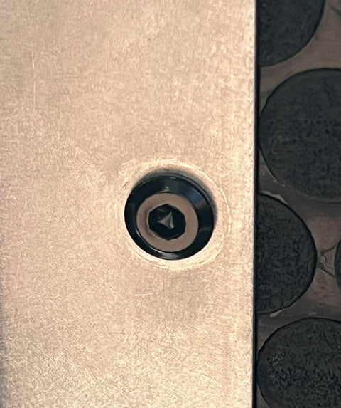 Close-up of a black M6 flat head Allen bolt installed in furniture, part of a 12 Pack M6 22mm Black Flat Head Allen Bolts For Furniture And Home Office Tables Desks Cabinets Wardrobes Made From 304 Stainless Steel Rust Resistant Heavy Duty Socket Cap Screws Built Tough set.