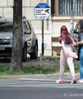 Two people walking near a security sign displaying 24 hour video surveillance on a street.