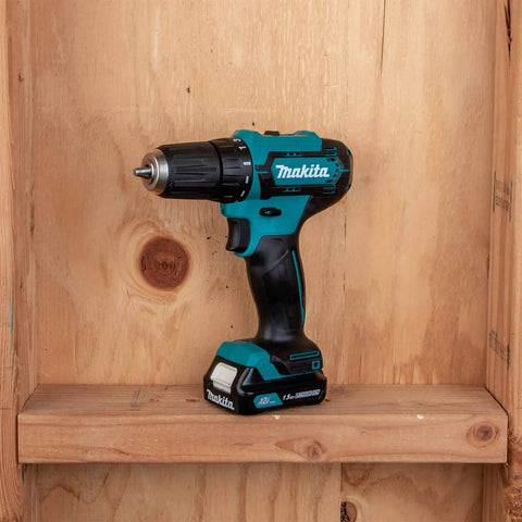 Lightweight 12V Max Cordless Drill Driver And Impact Driver Combo Kit With 1.5Ah Battery displayed on a wooden shelf.