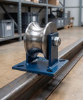 Smooth Operator V Shaped Gate Track Roller With Rock Solid 130X130mm Mounting Base on metal track in warehouse setting.