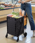 Person using Folding Shopping Cart With Dual Baskets And Waterproof Liner Workhorse Cart in grocery store with groceries.