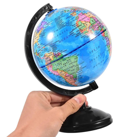 Person holding rotating 6 Inch World Globe With Stand kid friendly for learning geography at school or at home, black stand