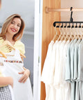 Woman smiling at clothes hanging on Six Pack Space Saving Closet Hangers For Dorm Rooms, Heavy Duty 9-Hole Wardrobe Organizers