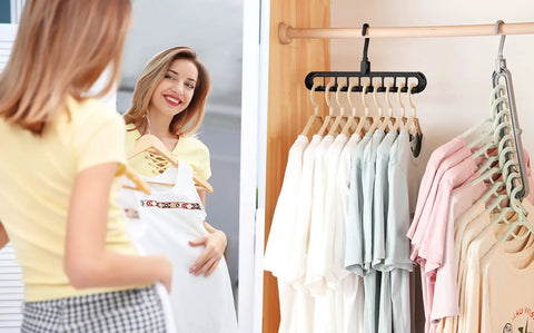 Woman smiling at clothes hanging on Six Pack Space Saving Closet Hangers For Dorm Rooms, Heavy Duty 9-Hole Wardrobe Organizers
