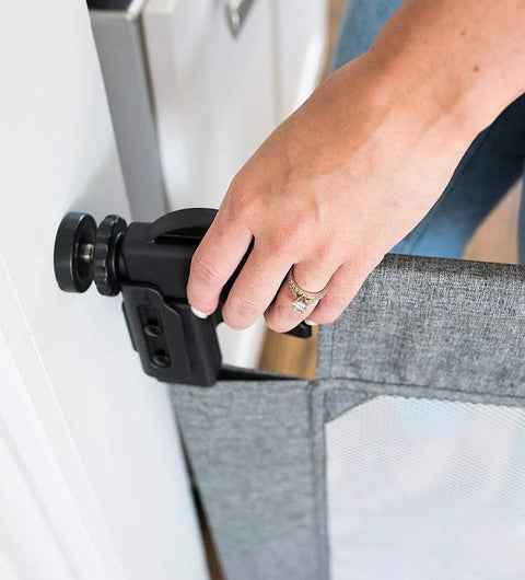 Close-up of Go With Me Portable Mesh Baby Gate For Hallways And Doorways Expandable From 30 To 48 Inches setup in a doorway, charcoal tweed.