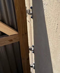 Top Shelf 304 Stainless Steel Gate Hinges provide a no sweat install for farm gates, showing mounted hinges on wooden barn structure.