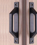 Front view of Four Piece Carbon Steel Sliding Barn Door Handle Set in Matte Black Finish installed on wood gate door, each handle 19.6 cm long.