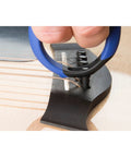 Premium Acoustic Guitar Bridge Pin Puller in use, rubber exterior, one-handed grip, safely lifting bridge pin from guitar.