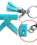 Close-up of a teal glittery resin charm with mini screw eye pin from 300Pcs Mini Screw Eye Pins and Hooks Set 10x5mm SelfTapping Screws.