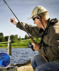 Man fishing with All Season 3 In 1 Home Weather Station With Brass Barometer, Thermometer, and Hygrometer on box near lake.