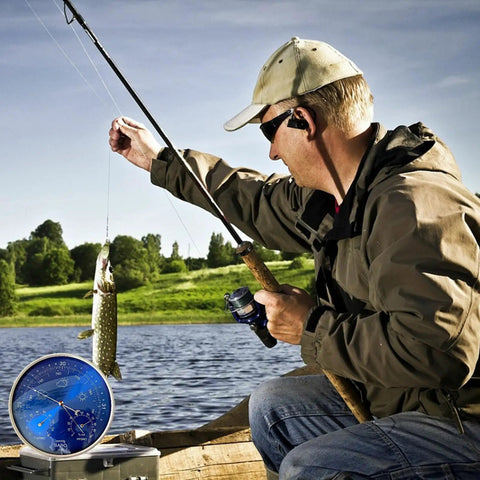 Man fishing with All Season 3 In 1 Home Weather Station With Brass Barometer, Thermometer, and Hygrometer on box near lake.