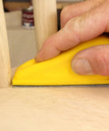 Hand using MicroZip Sander Kit With Assorted Grit Sanding Sheets For 3.5 Inch By 1 Inch Hook And Loop Pad on wooden surface
