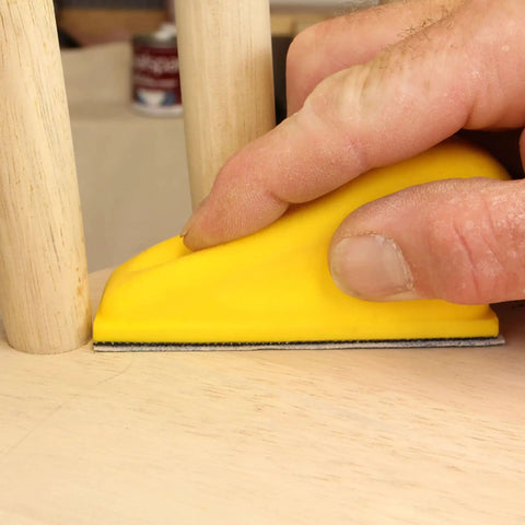 Hand using MicroZip Sander Kit With Assorted Grit Sanding Sheets For 3.5 Inch By 1 Inch Hook And Loop Pad on wooden surface