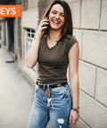 Woman standing on street, holding phone, keys clipped with Beefy Heavy Duty Locking Carabiner Clips 12kN Aluminum 7075 on jeans belt loop