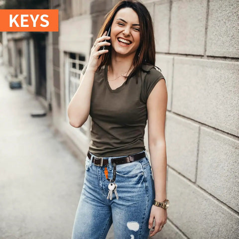 Woman standing on street, holding phone, keys clipped with Beefy Heavy Duty Locking Carabiner Clips 12kN Aluminum 7075 on jeans belt loop
