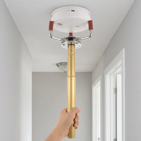 Skip The Ladder Drama With This Sturdy Aluminum Alloy Smoke Detector Remover Tool grabbing a fire sensor for easy disassembly.