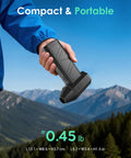 Man holding Cordless Air Duster With 110000 RPM Brushless Motor, Rechargeable 3 Gear Keyboard Cleaner outdoors with mountains in background.