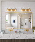 3 Light Modern Vanity Light Fixture in Brass Finish With Clear Glass Shades For Bathroom above a mirror in modern decor