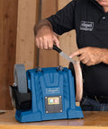 Person using Heavy Duty Workhorse 150W Water Cooled Bench Sharpener with knife on spinning grinding stone for blade tuning.