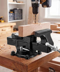Built Like A Tank Heavy Duty Bench Vise With 4 Inch Ductile Iron Jaws And Full Rotary Swivel Base on wooden table with drill