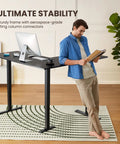 Man leaning on L Shaped Standing Desk 63 By 55 Inches Electric Sit Stand Table With Adjustable Height, black ergonomic computer desk