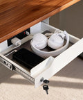 Kick Desk Chaos To The Curb With This Sleek Undermount Drawer Locker, featuring a white drawer holding headphones and a phone.