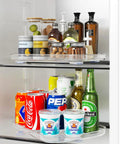 Clear Lazy Susan For Refrigerator And Pantry Cabinet Two Pack 360 Degree Rotating Organizer with drinks and condiments.