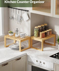 Heavy Duty Bamboo Cabinet Organizer Shelf Two Pack Stackable Kitchen Counter Rack Featuring Slatted Draining Surface To Air Out Dishes And Keep Counters Squeaky Clean with dishes and spice jars on countertops.