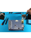 Solder Wire Spool Holder and Distributor with Heat Resistant Plastic Base next to tools on a blue electronics workspace