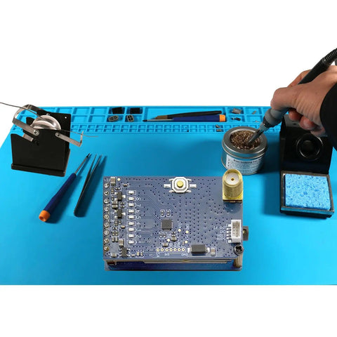 Solder Wire Spool Holder and Distributor with Heat Resistant Plastic Base next to tools on a blue electronics workspace