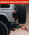 Spectra Fiber Soft Shackle Recovery 7/16 By 6 Inch demonstrating towing on SUV with braided sleeve and storage bag.